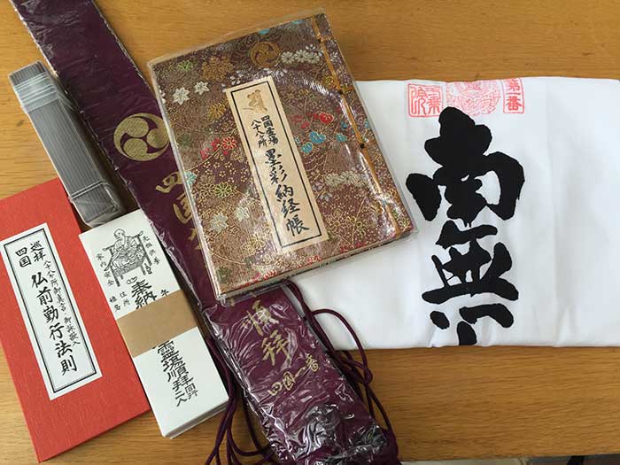 Pilgrim gear: white robe, staff, and nokyocho
